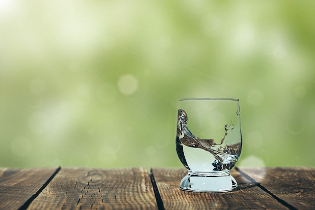 Splash of water in a glass on wood