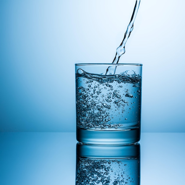 A splash of water is pouring in to a glass. Taken in Studio with a 5D mark III.