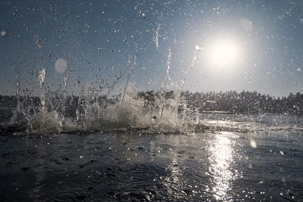 Splash of water in the lake against the background of the sun