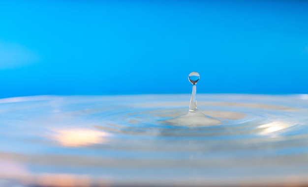 Photo splash water water drop splashsplash of the falling drops of water droplets on a blue background