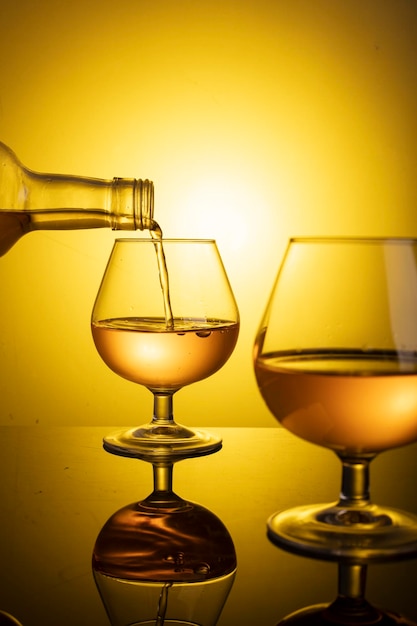 Splash of wine in a glass Drink in glass on a yellow background