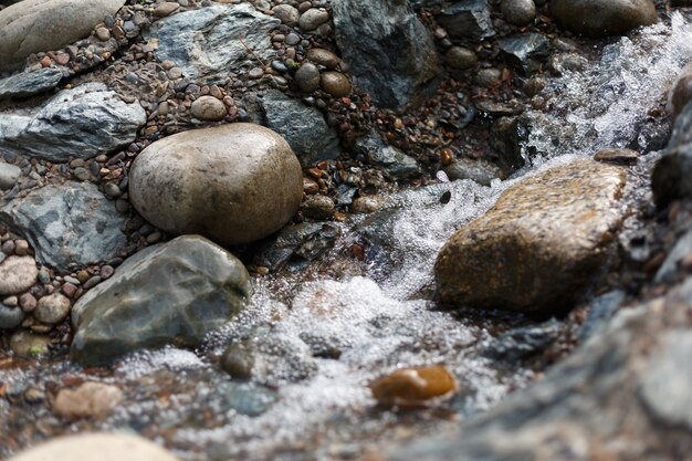 Photo splashes and drops of creek running over stones in japanese garden