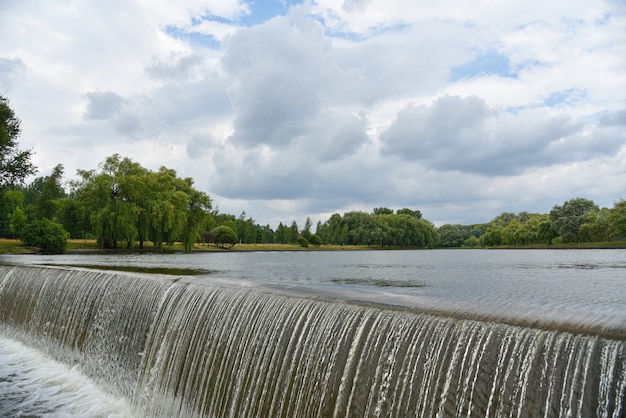 Spruzzi di una cascata su un fiume in un parco cittadino