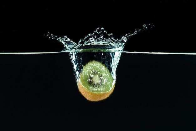 Splashing kiwi fruit on the water