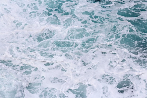 Splashing sea water with foam and bubbles at timang beach in sunny day yogyakarta indonesi