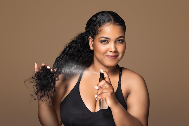 Split ends treatment beautiful brazilian plus size lady spraying detangling spray on hair