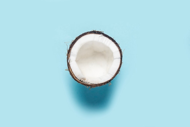 Split half of a coconut on a blue background.