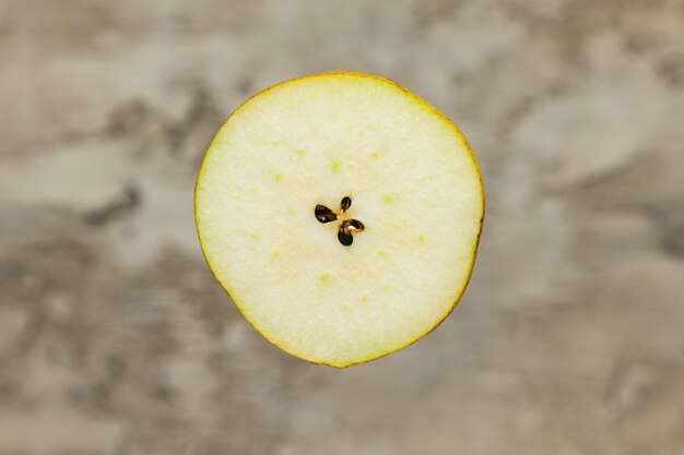 Photo a split pear on a blurred concrete wall.