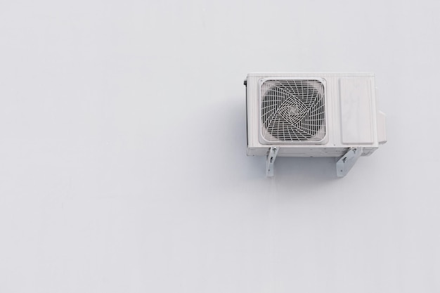 Foto split-systeemeenheid voor buitenairconditioner op witte muur met kopieerruimte
