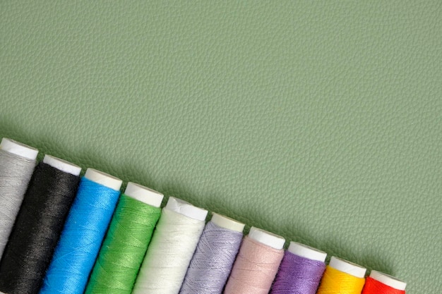 Spoelen met multi gekleurde naaigarens groene achtergrond