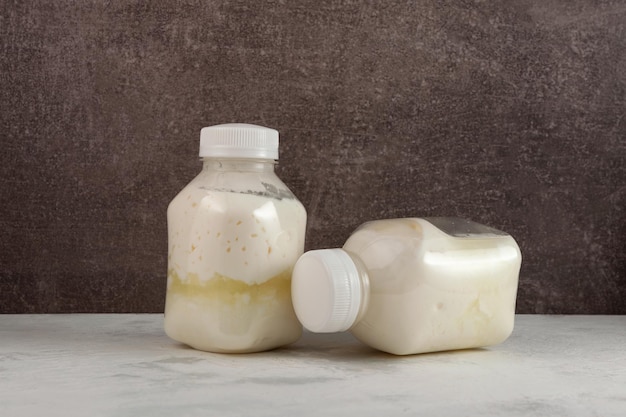 Spoiled dairy products in disposable plastic bottles Bloated swollen bottles. Improper storage food