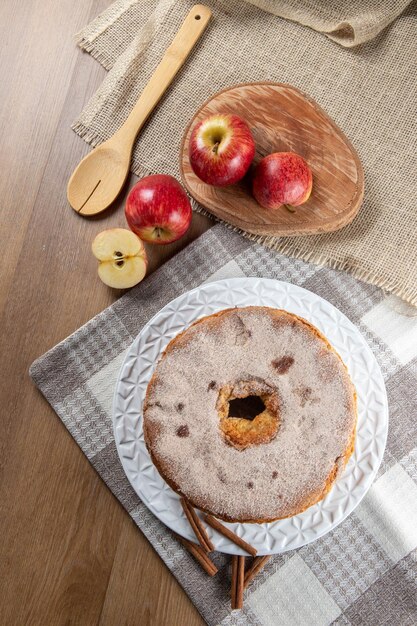 Sponge cake or chiffon cake with apples so soft and delicious sliced with ingredients cinnamon eggs flour apples on wooden table Home bakery concept for background and wallpaper Top view