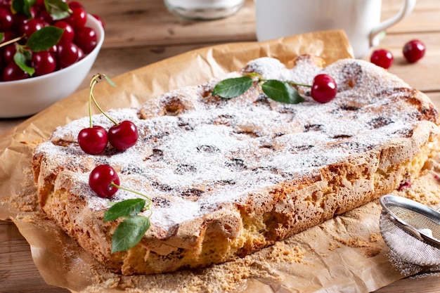 Sponge cake with cherries on a table selective focus Homemade cake