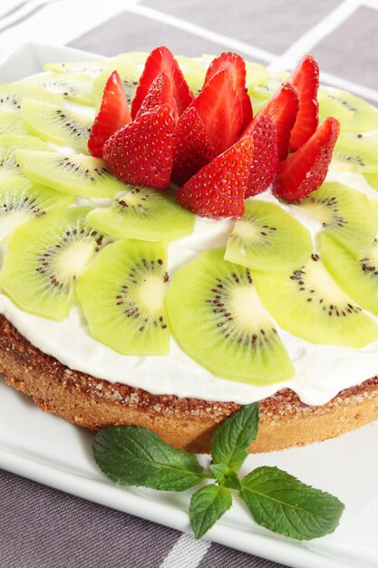 Sponge cake with the cream of kiwi and the strawberries