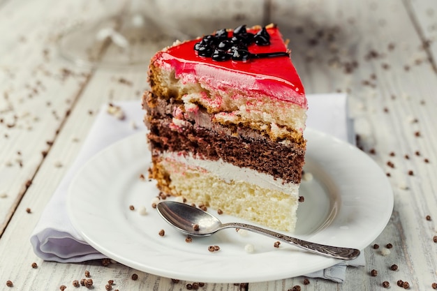 Sponge cake with fruit jelly on wooden background