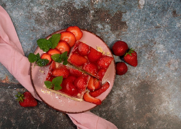 Sponge cake with strawberries on a dark background