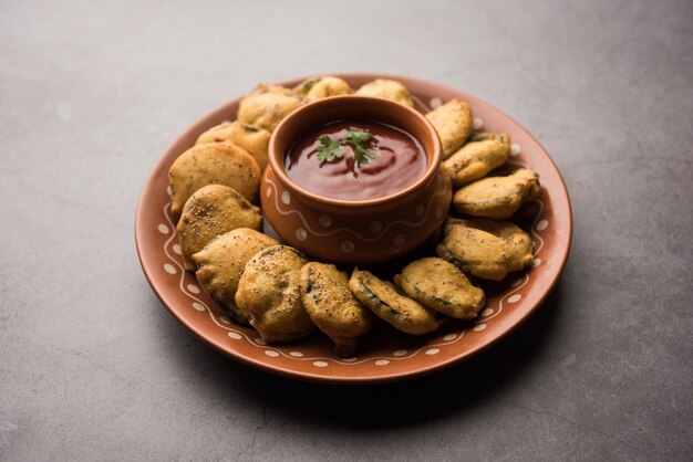 스펀지 조롱박 튀김 또는 gilki bhaji 또는 bajjiÃƒÂ‚Ã‚Â orÃƒÂ‚Ã‚Â pakora는 토마토 케첩, 선택적 초점과 함께 제공되는 인도 스낵 품목입니다.