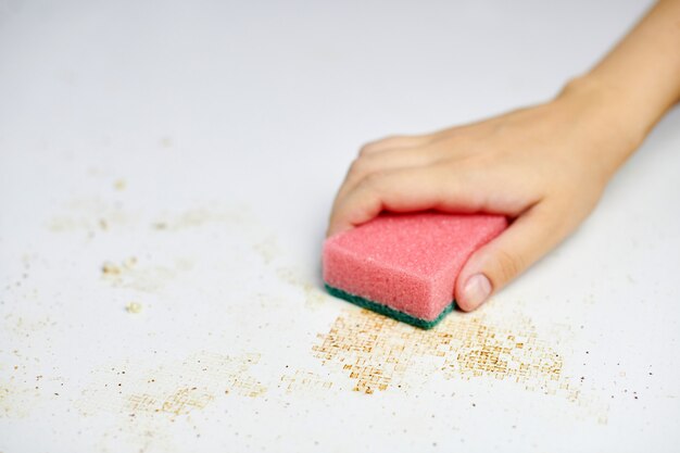 Photo sponge in a woman's hand removing dirt