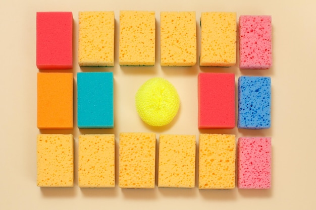 Sponges of different colors on a beige background