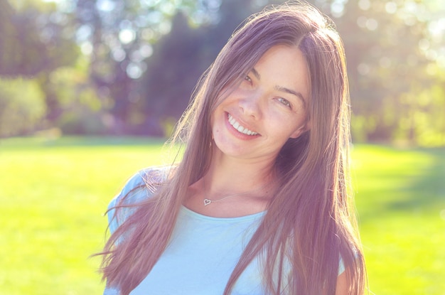 Spontaan portret van gelukkige glimlachende mooie vrouw in openlucht, natuurlijke meisjesschoonheid zonder make-up.