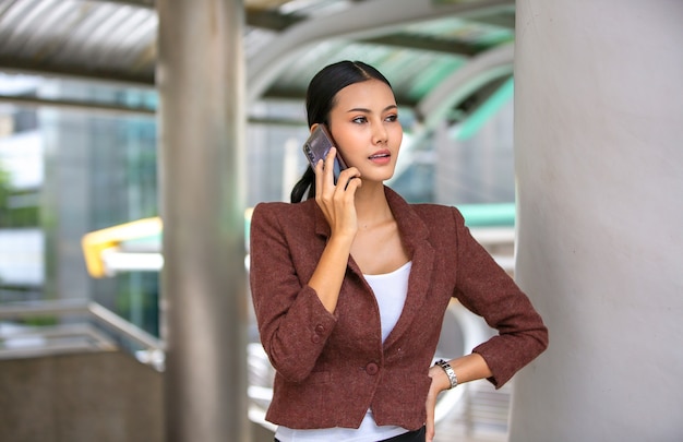 Spontane portretten van bedrijfsvrouwen die mobiele telefoon met behulp van openlucht