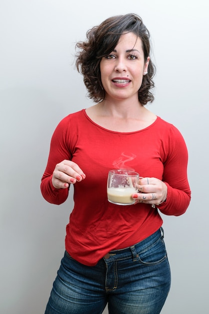 Spontaneous photo. Brazilian woman facing the camera with a mug of cappuccino and telling a story.