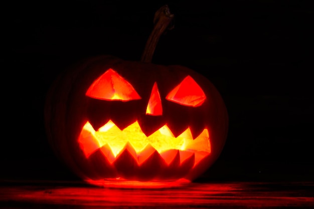 Spooky Halloween pompoen jackolantern met brandende kaarsen op donkere achtergrond