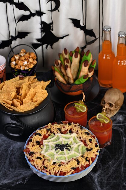 Фото spooky halloween seven layer taco dip: превратите классическую закуску в хэллоуин с черным оливковым пауком.