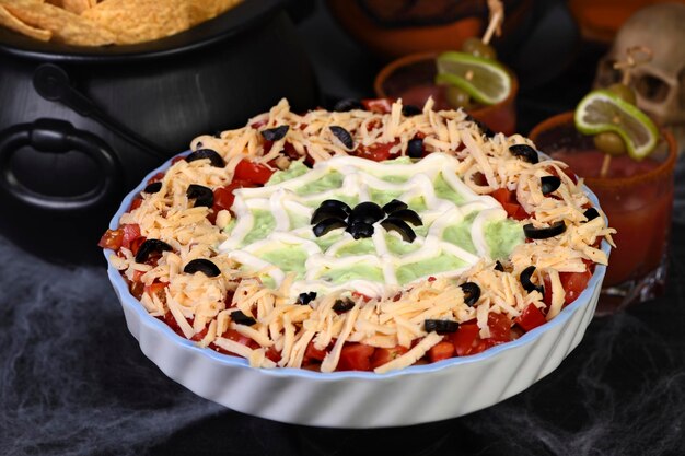 Spooky halloween seven layer taco dip verander een klassiek aperitief in een halloween-favoriet met slechts