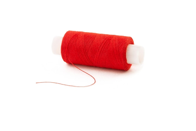 白い孤立した背景に赤い糸のスプール