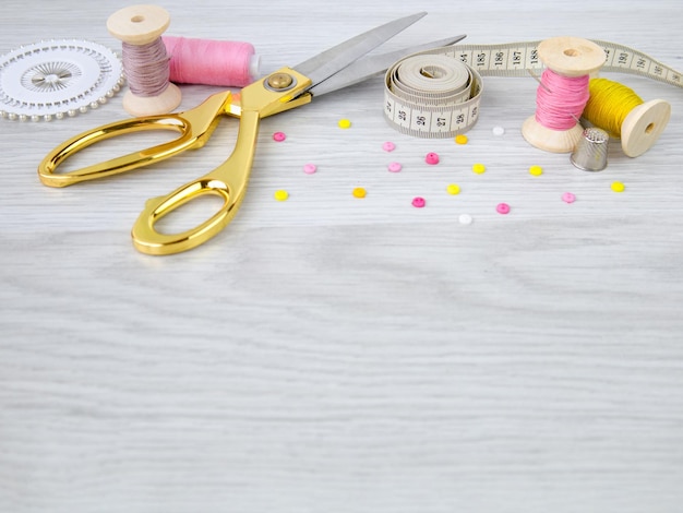 Photo a spool of threada needle and buttons on a wooden table