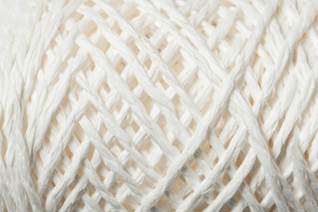 Spool of white linen rope, textured background