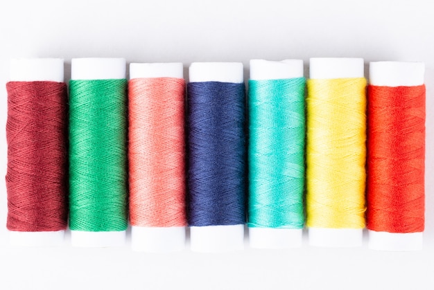 Spools of colorful threads in a row. Closeup