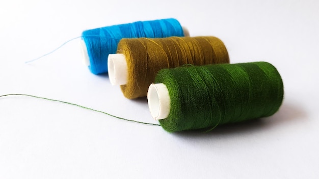 Spools of colorful yarn on a white background