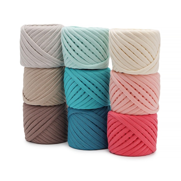 Spools of multicolored cotton threads on a white background Cotton yarn in ball and bobbins