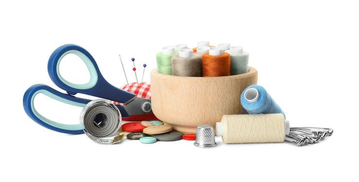 Photo spools of threads and sewing tools on white background