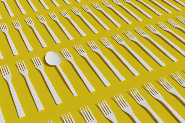 Photo a spoon among a pile of forks on a yellow surface.