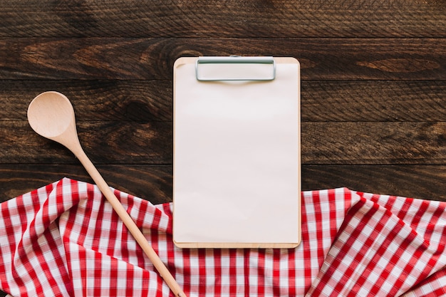 Photo spoon and clipboard near napkin