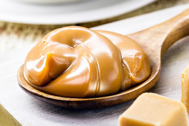 Spoon of dulce de leche or homemade sweet caramel called Dulce de lethe in Brazil typical food of the June festivities