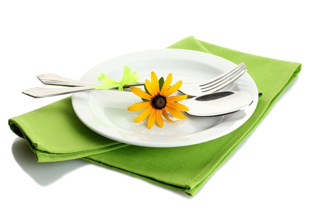 Spoon fork and flower on plate isolated on white