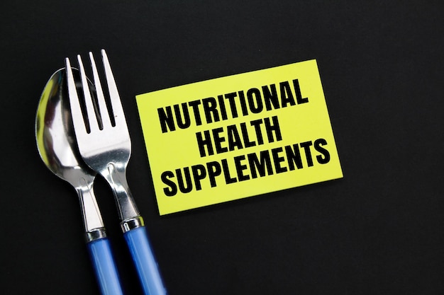 Nutritional Health Supplements 영양 건강이라는 단어로 색칠된 숟가락 포크와 종이