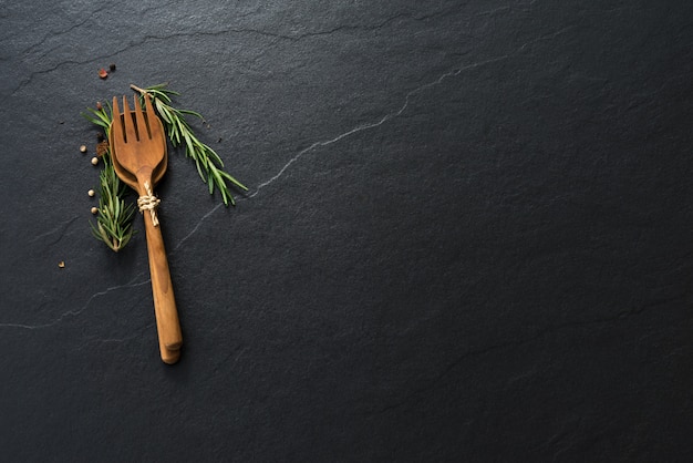 Photo spoon and fork pepper on black marble background with copyspace