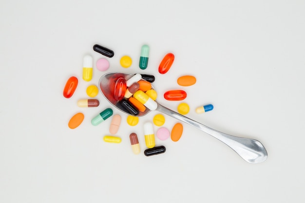 Photo spoon full of colored pills isolated