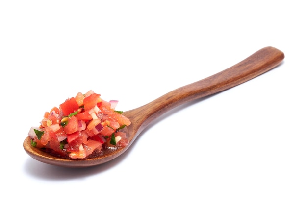 Spoon full of tomato salsa dip isolated on white background