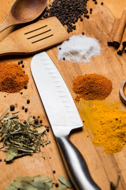 Photo spoon knife and heap of spices on the table