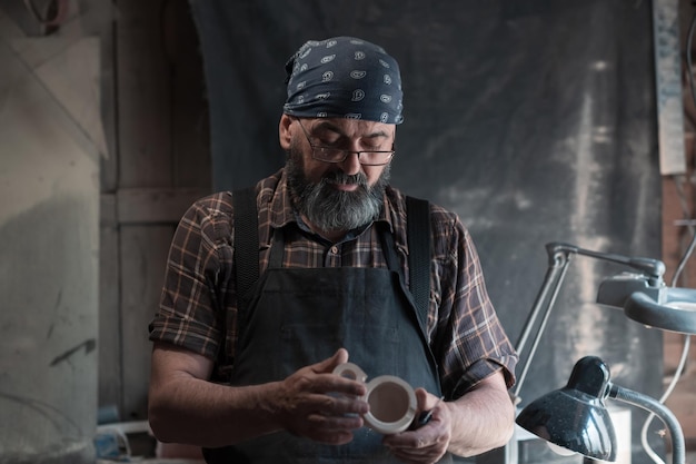 Spoon master in his workshop with wooden products and tools. High quality photo