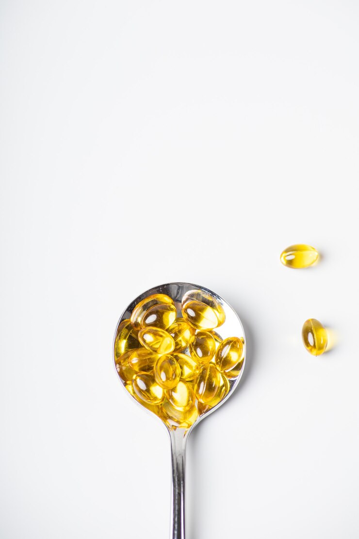 Spoon of omega-3 vitamins on a light background