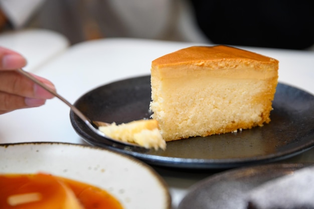 Cucchiaio scavando la cheesecake alla crema pasticcera sul piatto