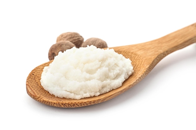 Spoon of shea butter and nuts on white background