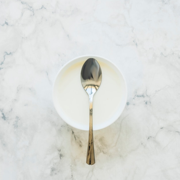 Photo spoon on white bowl on table